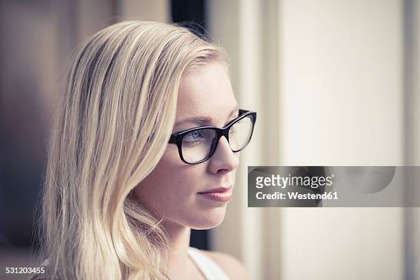 portrait of young woman wearing glasses - minder verzadiging stockfoto's en -beelden