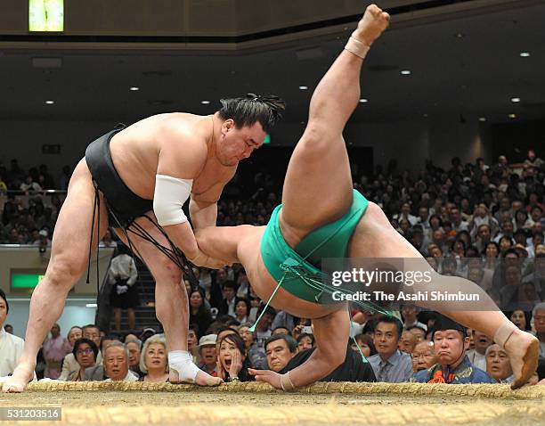 Mongolian yokozuna Harumafuji throws Yoshikaze to win during day six of the Grand Sumo Summer Tournament at Ryogoku Kokugikan on May 13, 2016 in...