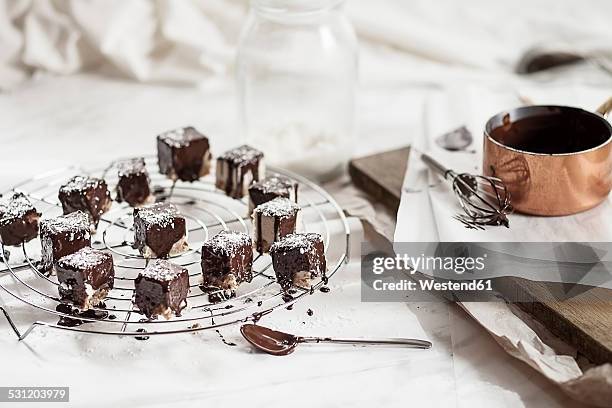 preparation of vegan cheese cake bites with chocolate icing - chocoladeglazuur stockfoto's en -beelden