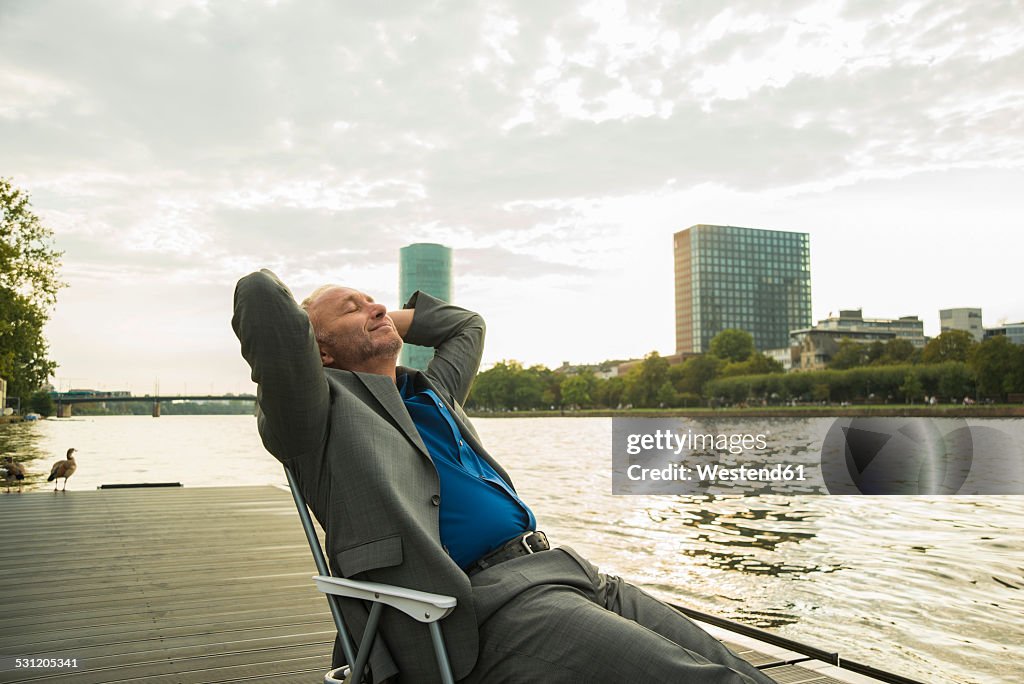 Germany, Frankfurt, relaxed businessman at river Main