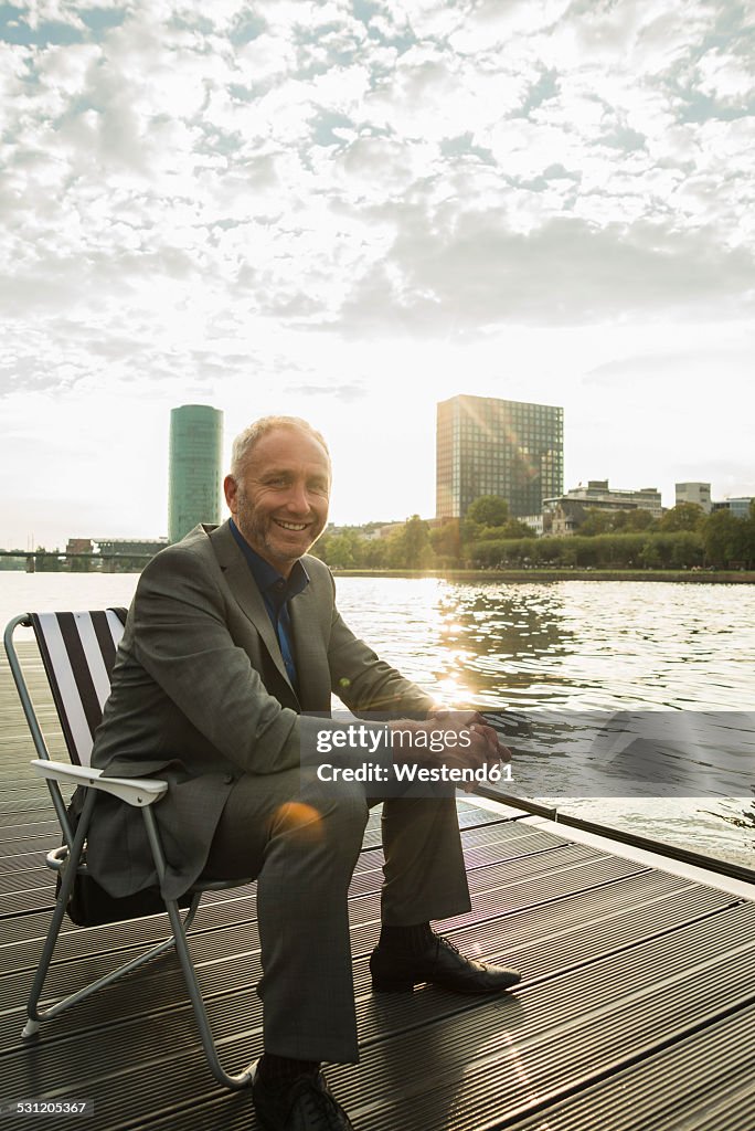 Germany, Frankfurt, relaxed businessman at river Main