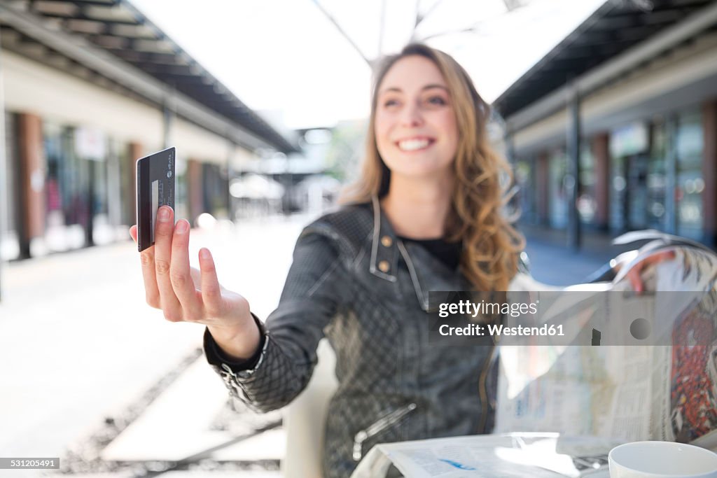 Young woman in a cafe paying with credit card