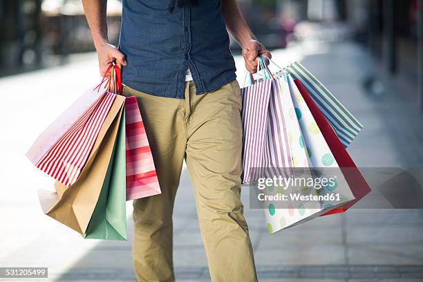 man carrying lots of shopping bags - men shopping stock pictures, royalty-free photos & images