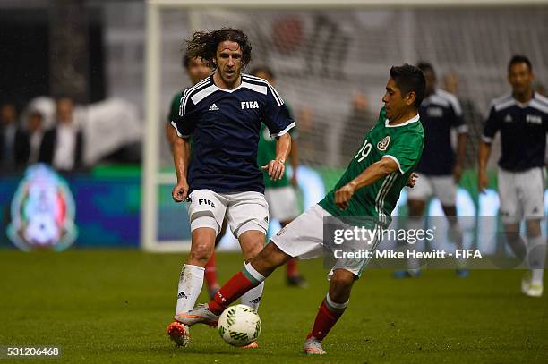 Carles Puyol of FIFA Legends challenges Jorge Campos of Mexican Allstars during an exhibition match between FIFA Legends and Mexican Allstars to...