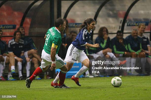 Mia Hamm of FIFA Legends battles for the ball with Alberto Garcia Aspe of MexicanAllstars during an exhibition match between FIFA Legends and...