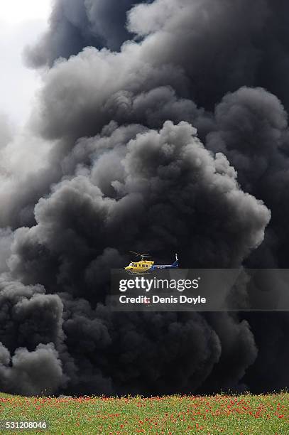 Helicopter drops water onto burning tyres at an illegal dump on May 13, 2016 in Sesena Nuevo, Spain. The dump, which stored over 75.000 tonnes of...