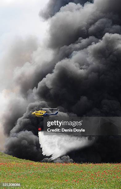 Helicopter drops water onto burning tyres at an illegal dump on May 13, 2016 in Sesena Nuevo, Spain. The dump, which stored over 75.000 tonnes of...