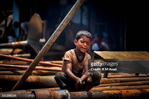 Little boy works in a metal workshop in Dhaka, Bangladesh, June 17, 2015. In the shipyard every worker is full of activity, no one have any time to...