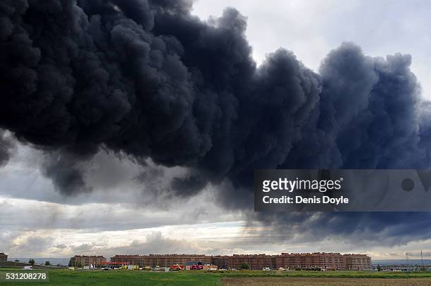 Toxic smoke rises over the housing estate of Nueva Sesena near Madrid after an illegal tyre dump went on fire on May 13, 2016 in Sesena Nuevo, Spain....