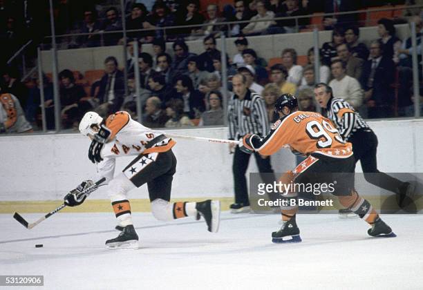 Mario Lemieux of the Wales Conference and the Pittsburgh Penguins skates with the puck as Wayne Gretzky of the Campbell Conference and the Edmonton...