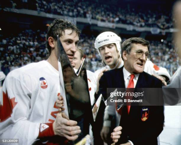 Mark Messier and Wayne Gretzky of Canada recieve the Canada Cup Trophy from Alan Eagleson after defeating the Soviet Union in Game 3 of the Canada...