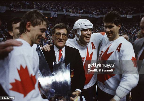 Mark Messier, Ray Bourque and Wayne Gretzky of Canada recieve the Canada Cup Trophy from Alan Eagleson after defeating the Soviet Union in Game 3 of...