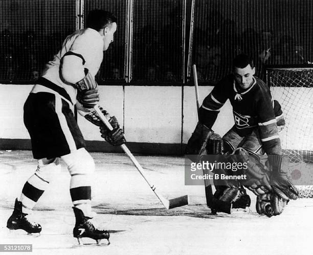 Sid Abel of the Chicago Black Hawks takes a shot on goalie Jacques Plante of the Montreal Canadiens during an NHL game circa 1952 at Chicago Stadium...