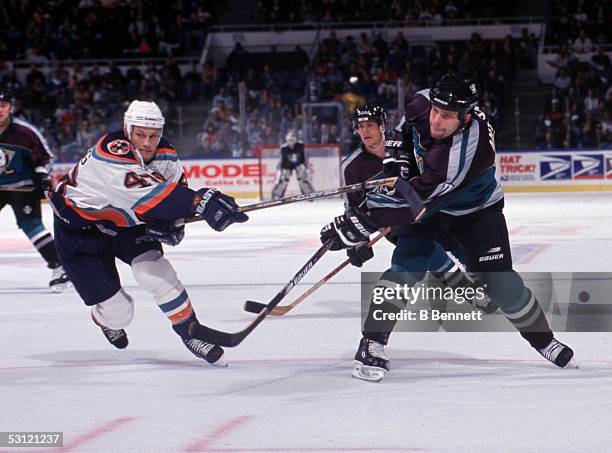 Anahiem's Shawn Antoski lets a shot go as Warren Luhning of the Islanders tries to stick check.