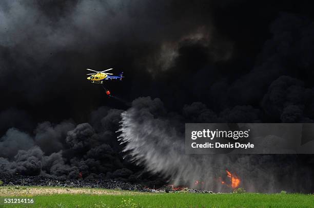 Helicopter drops water onto burning tyres at an illegal dump on May 13, 2016 in Sesena Nuevo, Spain. The dump, which stored over 75.000 tonnes of...