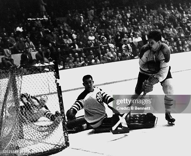 Jean Beliveau of the Montreal Canadiens scores on goalie Don Simmons of the Boston Bruins on March 3, 1957 at the Boston Garden in Boston,...