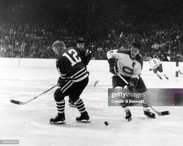 Jean Beliveau of the Montreal Canadiens looks to control the puck as Pat Stapleton of the Chicago Blackhawks over skates it during Game 3 of the 1968...