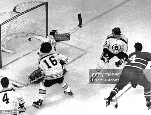 Jean Beliveau of the Montreal Canadiens scores on goalie Ed Johnston of the Boston Bruins as Dallas Smith, Derek Sanderson and Bobby Orr look on...
