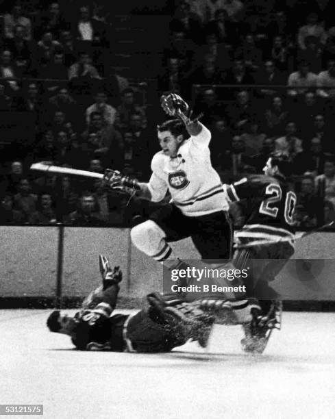 Jean Beliveau of the Montreal Canadiens leaps over goalie Cesare Maniago of the New York Rangers as his teammate Phil Goyette defends circa 1966 at...