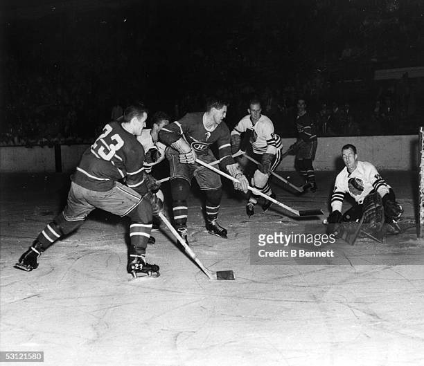 Goalie Al Rollins of the Chicago Blackhawks makes the save on Jean Beliveau of the Montreal Canadiens as Claude Provost of the Canadiens and Frank...
