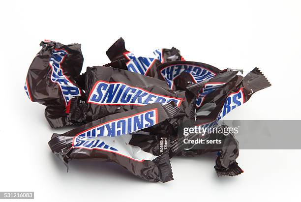 empty and crumpled snickers chocolate bars - snickers stock pictures, royalty-free photos & images