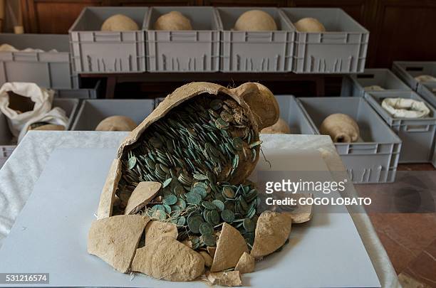 Roman era amphora filled with bronze coins is displayed at the archaeological museum in Sevilla on April 28, 2016 following their discovery during...
