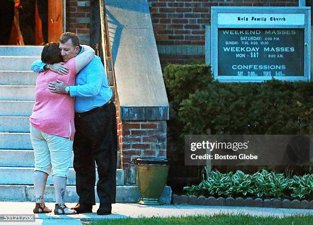 Two attendees hug leaving the Holy Family Catholic Church after a vigil for the victims of a stabbing spree the day before in Taunton, Mass., May 12,...