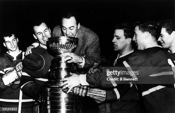 First year Montreal Canadiens coach Toe Blake drinks from the Stanley Cup with Don Marshall, Captain Butch Bouchard, Bernie Geoffrion, Dickie Moore,...