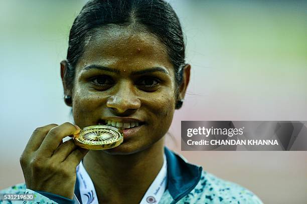 Dutee Chand of Odisha poses with her winning medal after victory in the 100 metre race during 20th Federation Cup National Senior Athletics...