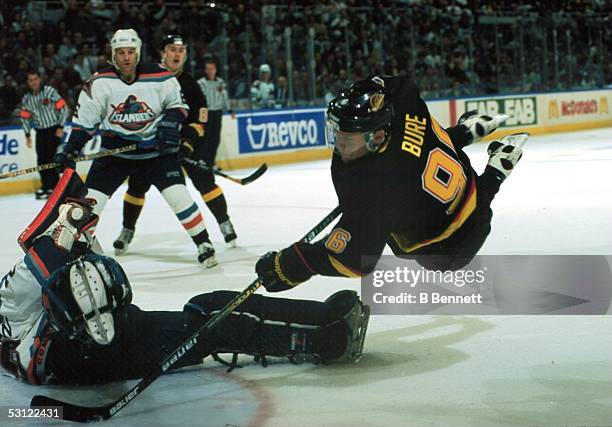 Awesome shot of Vancouver's Pavel Bure scoring on Islander goaltender Jamie McLennan while in mid-air.