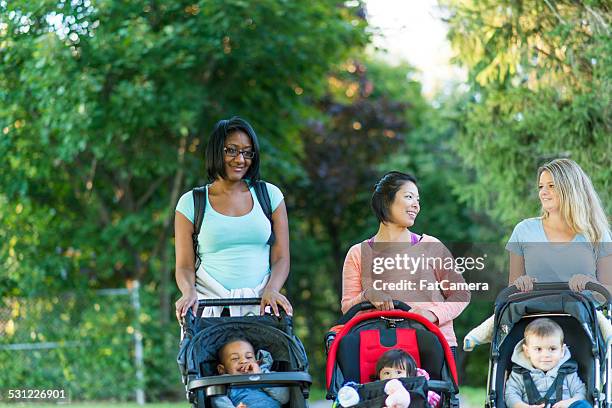 mother and her kid - three wheeled pushchair stock pictures, royalty-free photos & images