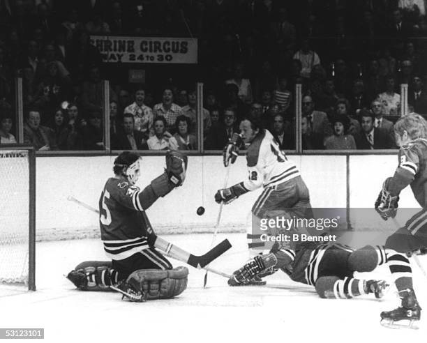 Yvan Cournoyer of the Montreal Canadiens shoots as goalie Tony Esposito of the Chicago Blackhawks makes the save during their game circa 1970's at...