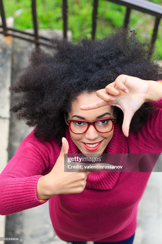 Young woman making finger frame