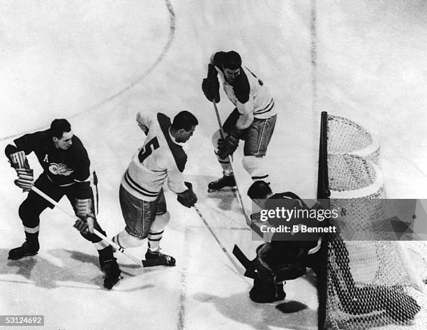 Bernie "Boom Boom" Geoffrion of the Montreal Canadiens scores past goalie Terry Sawchuk of the Detroit Red Wings as Red Kelly of the Red Wings...