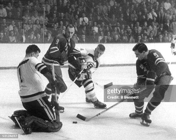 Bernie "Boom Boom" Geoffrion of the New York Rangers tries to score against Eddie Johnston of the Boston Bruins as Reggie Fleming of the Rangers and...