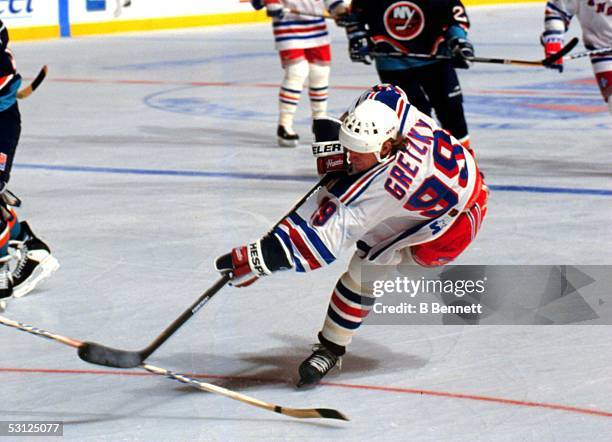 Wayne Gretzky of the New York Rangers shoots the puck during an NHL game against the New York Islanders circa 1997 at the Madison Square Garden in...