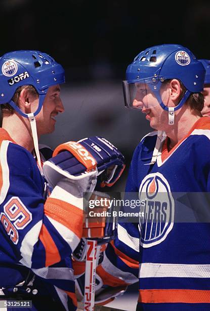 Wayne Gretzky of the Edmonton Oilers talks with teammate Jari Kurri during an NHL game circa 1987.