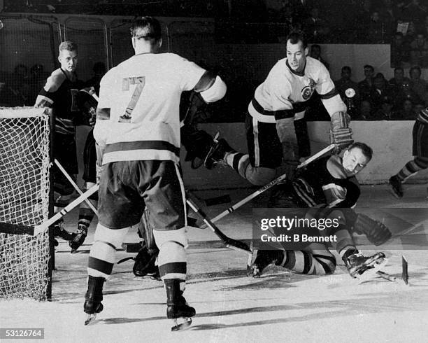 Gordie Howe and Ted Lindsay of the Detroit Red Wings fight for the puck during an NHL game against the Boston Bruins on December 28, 1952 at Olympia...