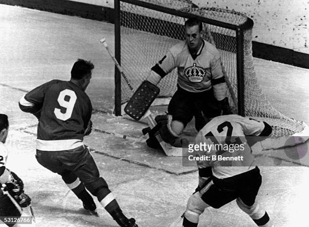 Goalie Wayne Rutledge of the Los Angeles Kings makes the save on Gordie Howe of the Detroit Red Wings as Brian Campbell of the Kings follows the play...