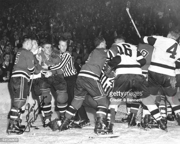 Lou Fontinato of the New York Rangers is held back after he and Gordie Howe of the Detroit Red Wings incite a brawl during their game in the 1950's...