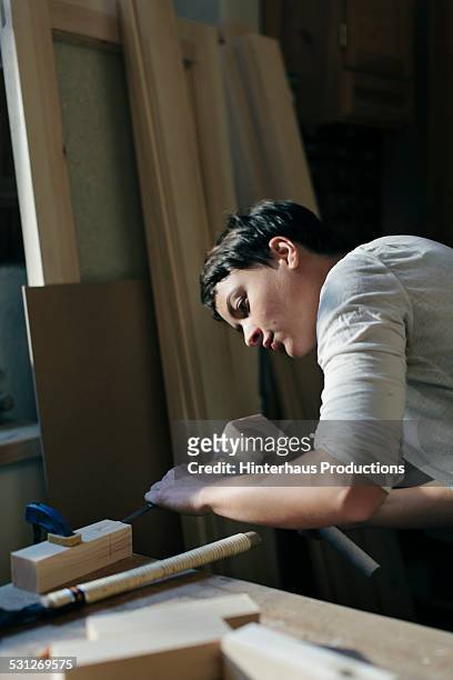 female carpenter working in workshop - rolling up sleeve stock-fotos und bilder