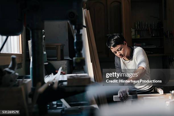 female carpenter working in workshop - taller-de-carpintería fotografías e imágenes de stock