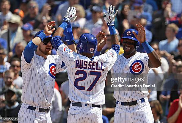 Addison Russell of the Chicago Cubs is greeted by Ben Zobrist and Jorge Soler after hitting a three-run home run in the 4th inning against the...