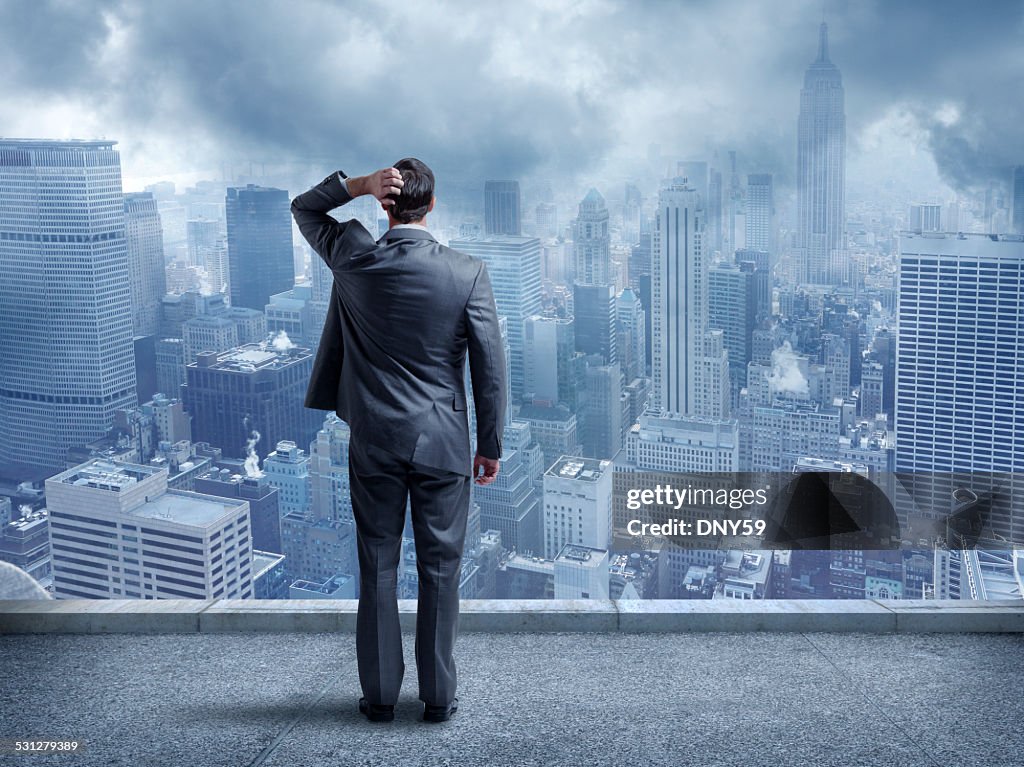 Perplexed Businessman Looking At Cityscape