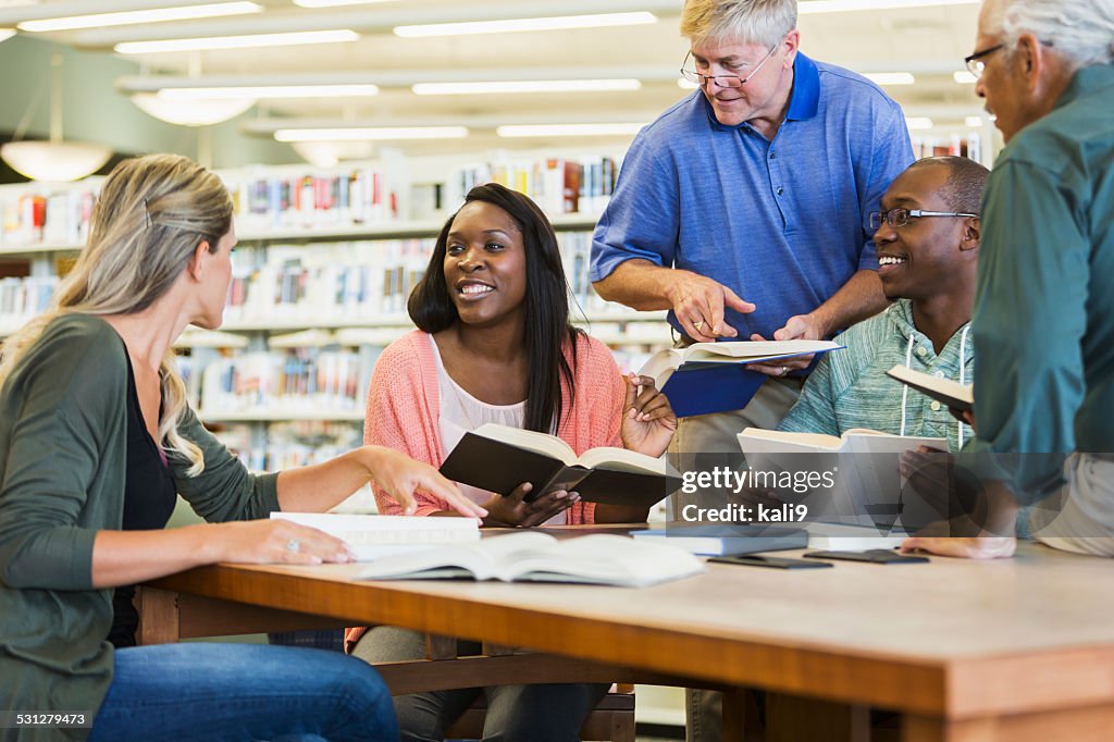 Adult students studying  together in library