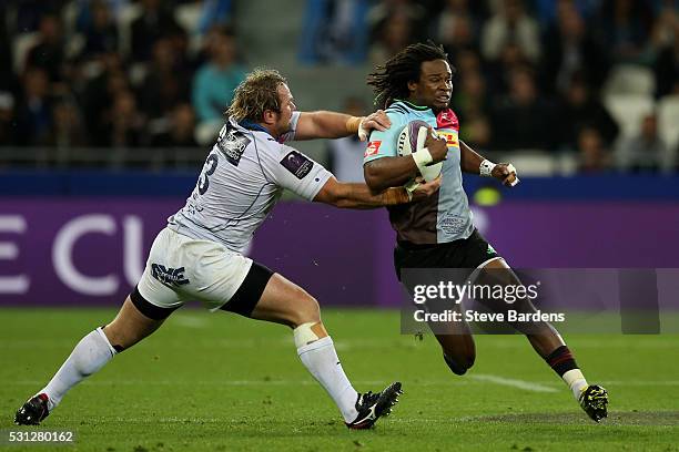 Marland Yarde of Harlequins is tackled by Jannie Du Plessis of Montpellier during the European Rugby Challenge Cup Final match between Harlequins and...