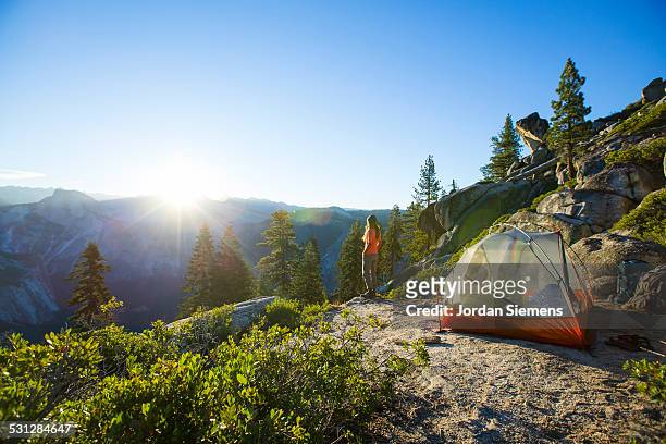 a woman watching sunrise from a tent. - mariposa county photos et images de collection