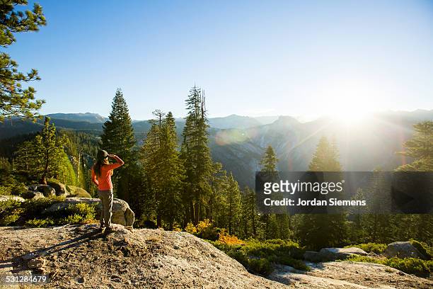 a woman watching sunrise while camping. - yosemite national park stock pictures, royalty-free photos & images