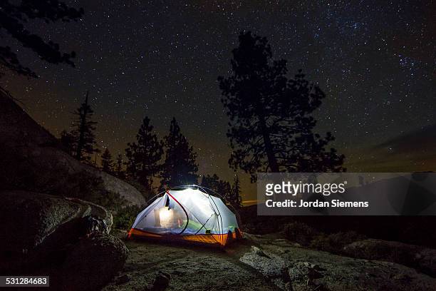 a tent under the night sky. - tent stock-fotos und bilder