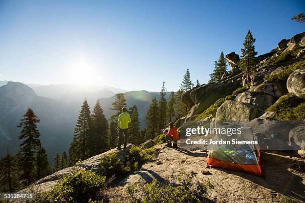 a couple watching sunrise while camping. - yosemite stock-fotos und bilder